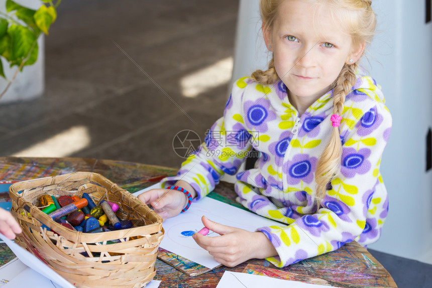 小女孩在纸上认真的画画图片