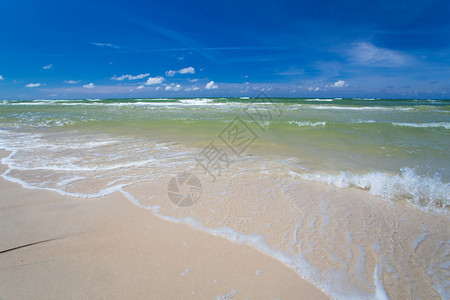 沙空海滨在清蓝天空有冲浪波图片