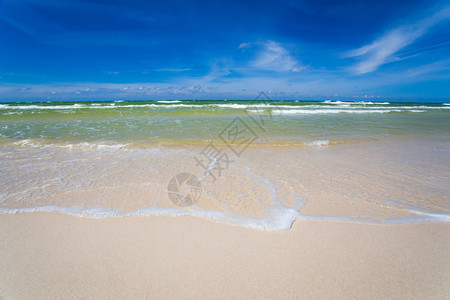 沙空海滨在清蓝天空有冲浪波图片
