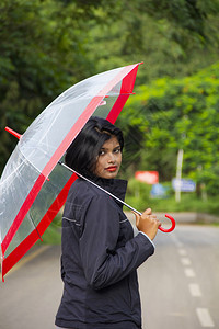印度女孩拿着雨伞往回看图片