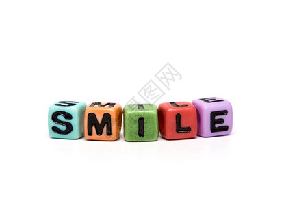 由带有字母的多色子玩具立方体制成的微笑单词图片