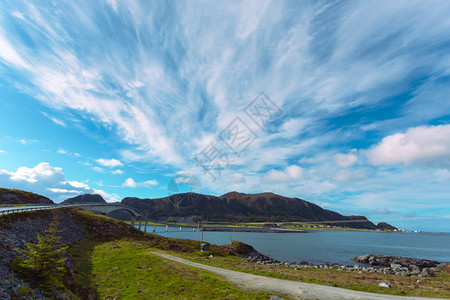 通向岩石岛的桥状屿其背景丘陵南边的云彩风景美丽图片