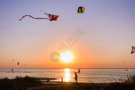 女孩在日落时海边放风筝图片