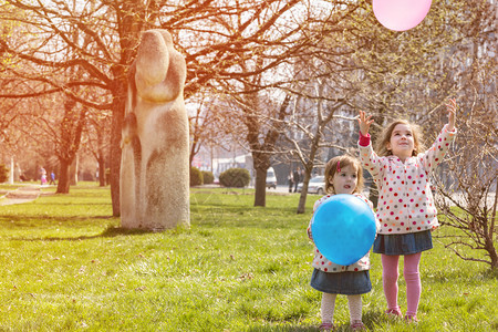 带着气球的小姐妹们在公园里玩图片