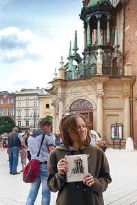 美丽的少女坐在广场上画着城堡图片