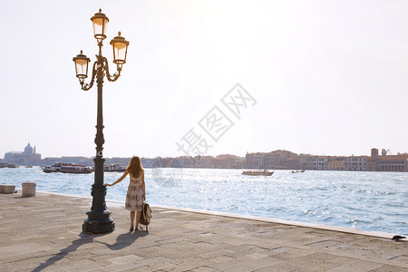 女孩站着看大运河在威尼斯Italy图片