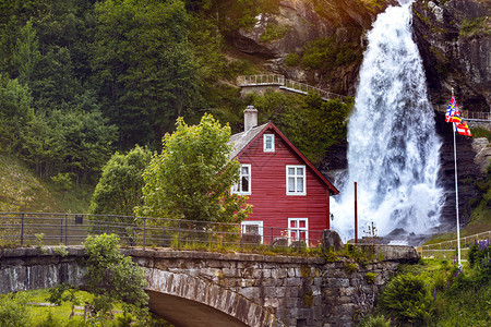 传统挪威红木屋和背景中的斯坦达尔福森瀑布图片