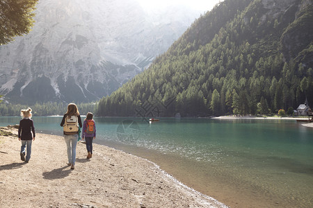母亲和女儿环绕着湖走图片