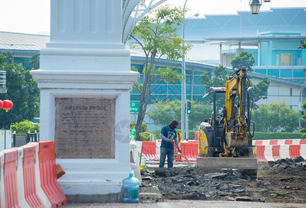 位于市中心Sinapore街头路面翻新工程的挖掘机工图片