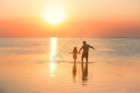 父亲和女儿平静的走在海边图片
