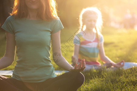 母亲和女儿在公园做瑜伽图片