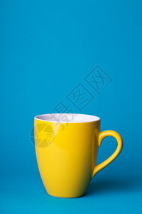 蓝色背景的美丽咖啡黄杯图片