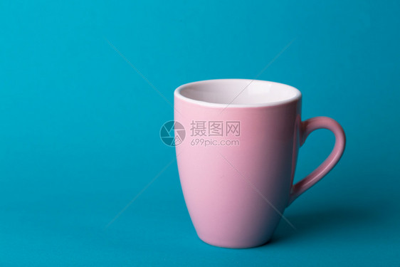 蓝色背景的美丽粉红咖啡杯图片