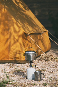 快乐之旅背景中的燃烧器保龄球杯子和古老的黄色帐篷图片
