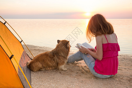 日落时海边有条狗的女孩在海滩上度过快乐的周末在阿佐夫海的乌拉尼风景图片