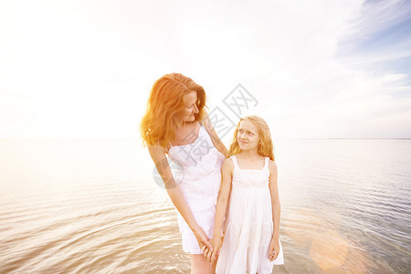 快乐的周末母亲和女儿在海边玩耍图片