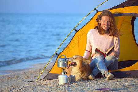 海边的帐篷里坐着女人和一只狗图片