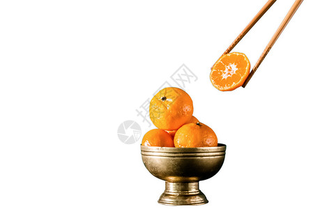 黄铜旧碗中新鲜的橙子有复制空间将白底的筷子摘橙减少一半图片
