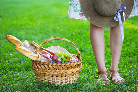 女孩和篮子野餐用面包葡萄酒眼镜和卷饼图片
