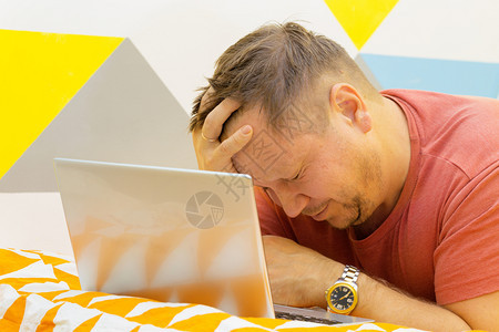 男人在床上工作笔记本电脑上工作人类情感图片