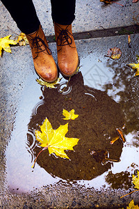 在雨季穿皮靴踩水坑的女孩图片