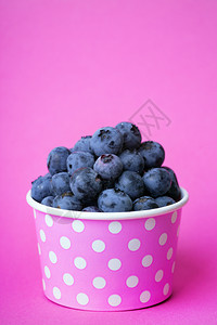 蓝莓用粉红背景的明亮玻璃杯图片