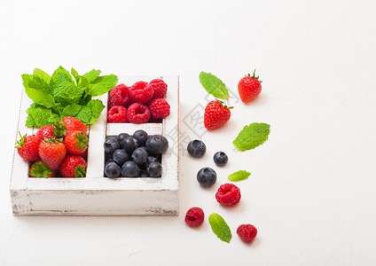 在厨房桌背景的白木盒子中新鲜有机果子文本空间草莓蓝和薄片叶图片