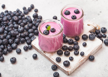 鲜自制奶油蓝莓酸在石桌背景的旧木板上用新鲜蓝莓图片