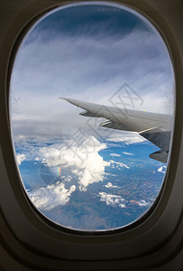 透过窗外云层看着飞机翼图片