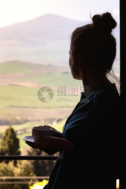 有咖啡的女孩站在窗外的户旁边外的图斯卡风景图片