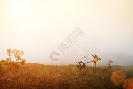 快乐旅行者站在山上日出落和耀斑旅行假期的概念图片