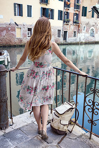 女孩站在桥上河口的在威尼斯Italy图片