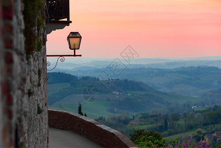 日落时从圣吉米尼那的墙壁中凝视山谷的景象图片