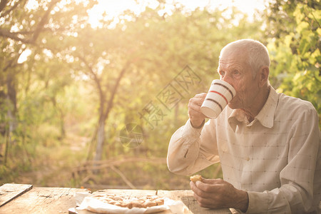 高年男子在花园喝茶图片