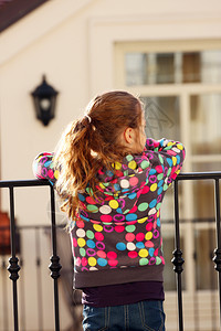 女孩站在阳台上看街景图片