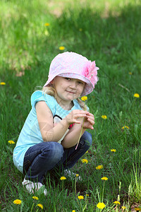 小孩坐在公园的草地上图片