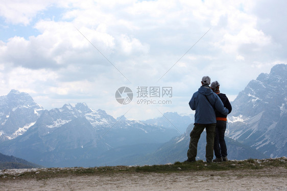 两个远足者站在一块岩石上望着山岳图片