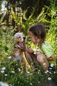 小女孩和狗坐在草地上图片