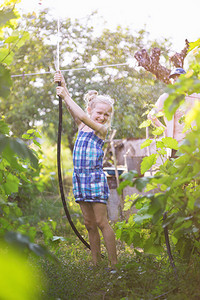 夏天小女孩在雨下的花园里玩得开心图片