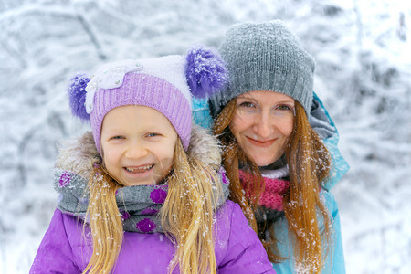 幸福家庭母亲与在冬季散步时笑着女儿的母亲图片