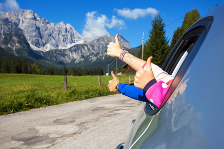 快乐的家庭男人和孩子的手在山地背景的汽车旁观图片