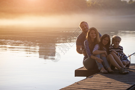 日落时分坐在德尼伯河码头的幸福家庭图片