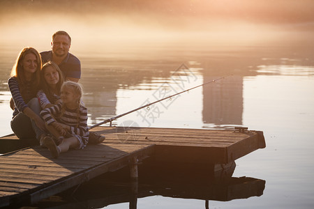 日落时分坐在德尼伯河码头的幸福家庭图片