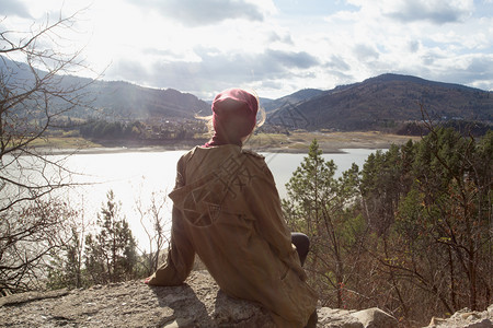 时装女潮人坐在罗马尼亚喀尔巴阡山脉的背景上图片