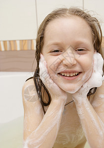 在洗澡时双手被肥皂覆盖的小孩图片