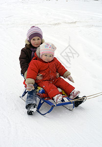 冬季散步小女孩坐在雪橇上图片