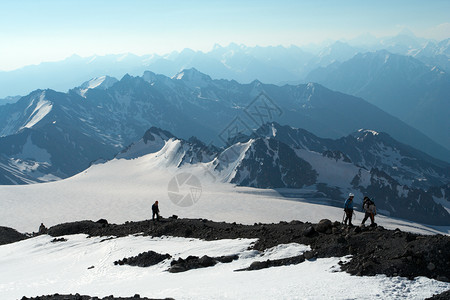 登山者在顶和上行走其背景是蓝天空图片
