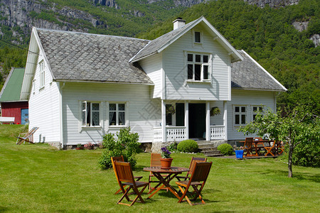 传统挪威木制房屋站在草坪和山丘上高清图片