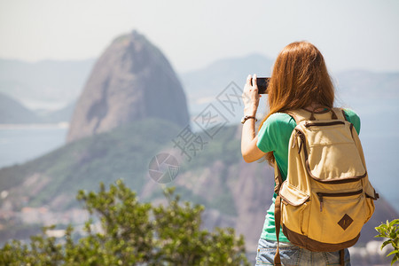 观光女游客在智能手机paodecur上拍照图片