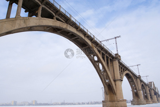 冰冻河流上方的铁路大桥宽角图片
